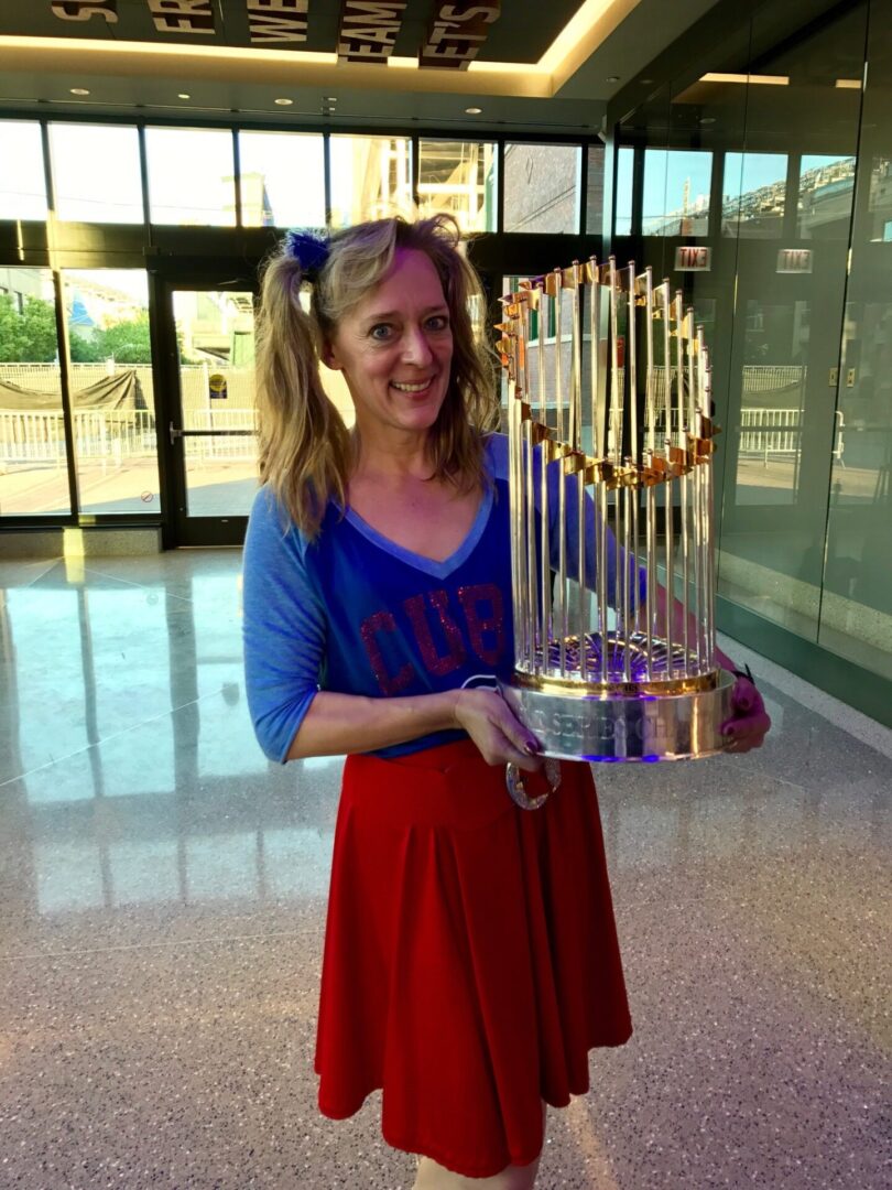 A woman holding up the world series trophy.